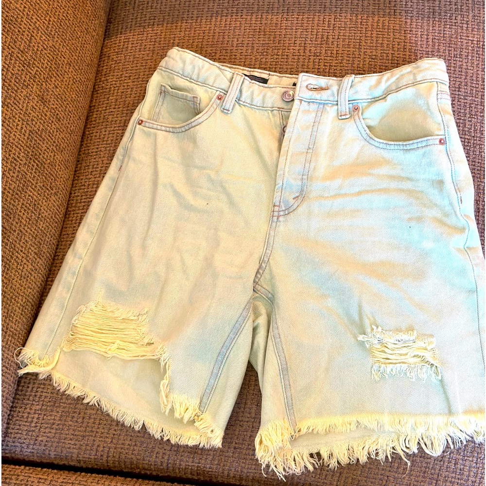 Tattered light green jean shorts